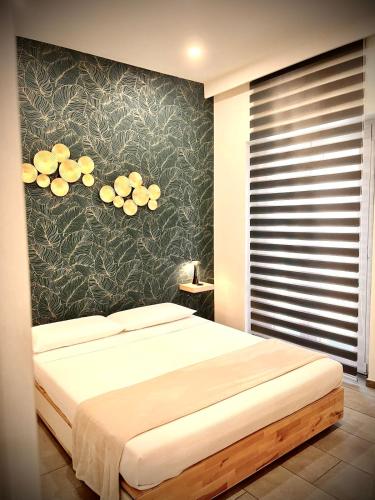 a bedroom with a bed and a wall with flowers at LAVIKA - Luxury Holiday Home in Acitrezza