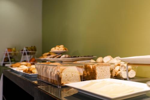 a buffet line with different types of bread and pastries at Punta Trouville Hotel in Montevideo