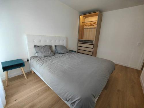 a bedroom with a large bed and a dresser at Le clos d'Asnières in Asnières-sur-Seine
