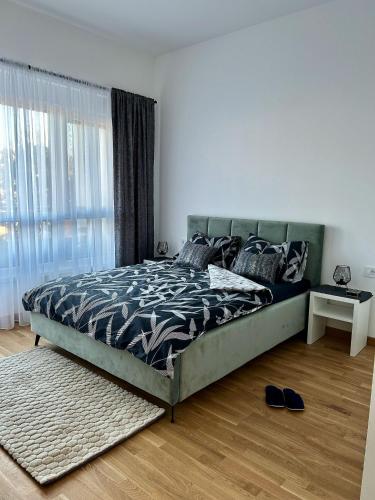 a bedroom with a large bed with a large window at Apartman Hera in Vrdnik
