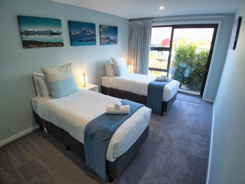 Habitación de hotel con 2 camas y ventana en Wineberry Lodge, en Wanaka