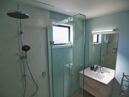 a bathroom with a glass shower and a sink at Wineberry Lodge in Wanaka