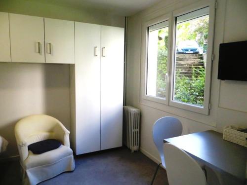 Cette chambre dispose d'un bureau, de chaises et d'une fenêtre. dans l'établissement Pratique, Complet Sûr, Métro et Parking; Proche du Centre, de la Gare, de la Rocade, d'un supermarché. Tout à Pied., à Toulouse