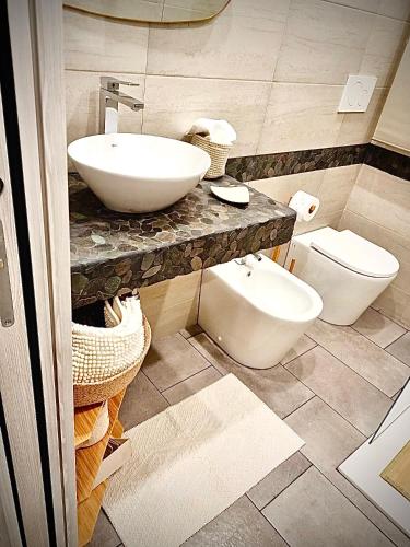 a bathroom with a sink and a toilet at LAVIKA - Luxury Holiday Home in Acitrezza