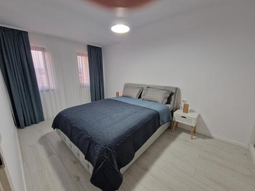 a bedroom with a large bed with a blue blanket at Apartament Eva in Cristian