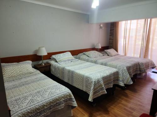 a room with three beds in a room at NEW HOTEL CRUZ DEL SUR in Concepción