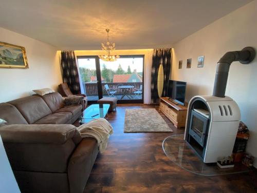 uma sala de estar com um sofá e um fogão a lenha em Das Hexenlandhaus em Braunlage