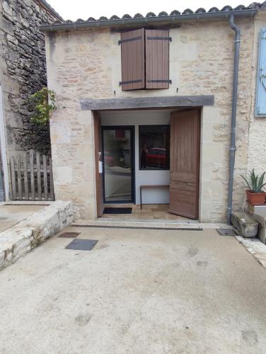 a garage with a wooden door and a building at gite de la tour in Montcuq