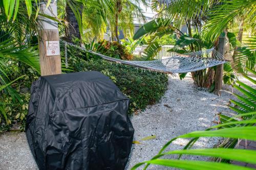 a hammock in a garden with palm trees at Anna Cabana Bungalow #1 in Holmes Beach