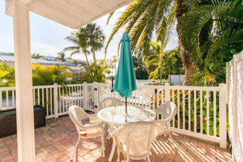 a patio with a table and chairs and an umbrella at Anna Cabana Bungalow #1 in Holmes Beach