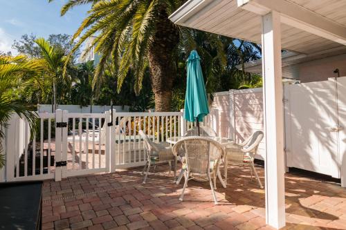 a table and chairs with an umbrella on a patio at Anna Cabana Bungalow #1 in Holmes Beach