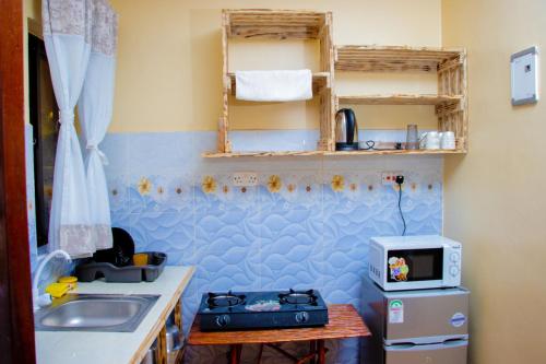 a small kitchen with a sink and a microwave at Vibrant Haven ~ Deux in Kilifi