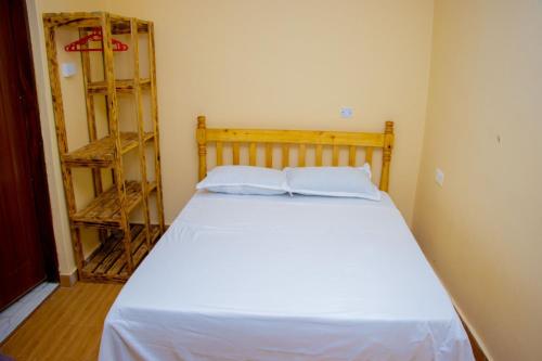 a bedroom with a white bed with two pillows at Vibrant Haven ~ Deux in Kilifi