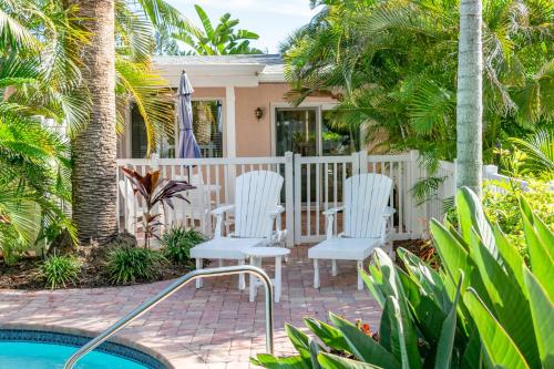 a house with white chairs and a swimming pool at Anna Cabana Bungalow #1 in Holmes Beach