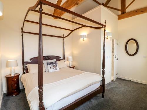 - une chambre avec un lit à baldaquin et un miroir dans l'établissement The Dairy, à Bakewell