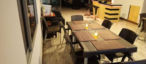 two tables in a restaurant with chairs and a counter at Hotel Palo Grande in Manizales