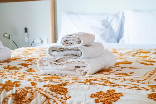a pile of towels sitting on top of a bed at Dinoulas Penthouse: Renovated Apt in the City Center in Athens