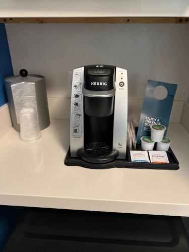 a coffee maker sitting on a counter next to a box at Holiday Inn Express & Suites Mobile - University Area by IHG in Mobile