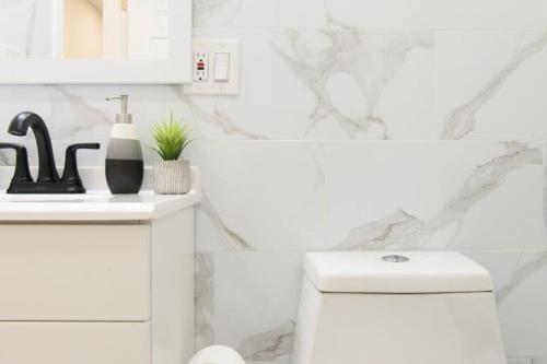 La salle de bains blanche est pourvue d'un lavabo et de toilettes. dans l'établissement New Modern Studio UES W D, à New York