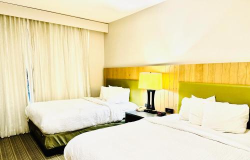 a hotel room with two beds and a window at Radiant Inn and Suites in Murfreesboro