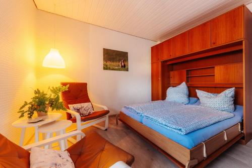 - une petite chambre avec un lit et une chaise dans l'établissement Haus Tippe, à Braunlage