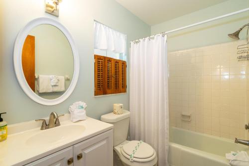 uma casa de banho com um lavatório, um WC e um espelho. em Snyders Rest A and B em Holmes Beach