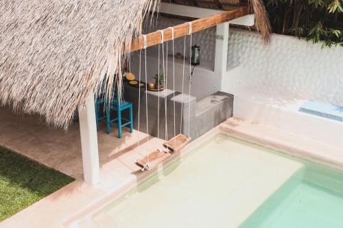 an overhead view of a swimming pool with a straw roof at Casa Kâi in Brisas de Zicatela