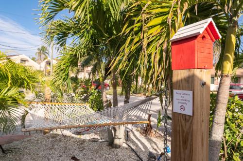 a hammock with a sign on it next to trees at Anna Cabana Bungalow #3 in Holmes Beach