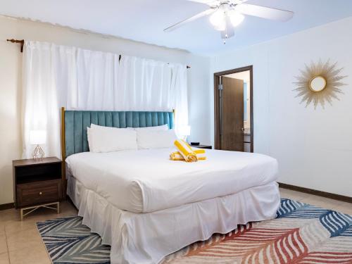 Schlafzimmer mit einem großen weißen Bett mit blauem Kopfteil in der Unterkunft Bollinger Duplex, A in Holmes Beach