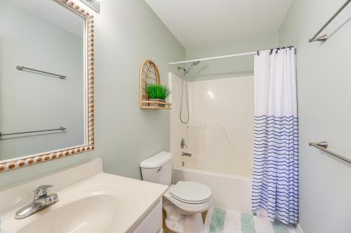 a white bathroom with a toilet and a sink at Well-Equipped Emerald Isle Townhome Pets Welcome! in Emerald Isle