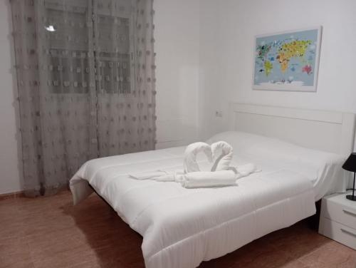 a white bed with a towel on top of it at Center Paradise Almerimar in Almerimar