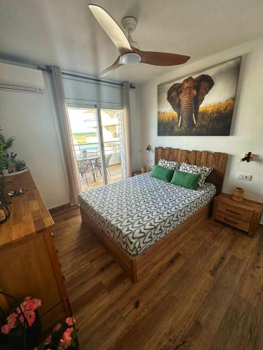 a bedroom with a bed and a painting of an elephant at Sunsetmare Vacational Apartment in Roses