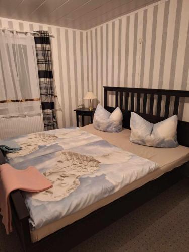 ein Schlafzimmer mit einem großen Bett mit weißer Bettwäsche und Kissen in der Unterkunft Haus Rosi in Lutzerath