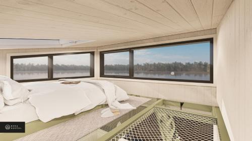 a bed in the middle of a room with windows at MiniBora Le beaumier - Cantons-de-l'Est in Bury