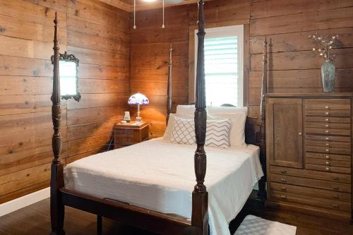 ein Schlafzimmer mit einem Himmelbett in einer Hütte in der Unterkunft Red Door Cottage in Waco