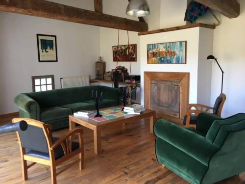 uma sala de estar com dois sofás verdes e uma mesa de centro em Lumineuse Et Spacieuse Maison Style Loft em Saint-Amour-Bellevue