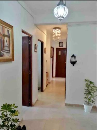 a hallway with doors and a chandelier at Charmante location ensoleillée in Alger