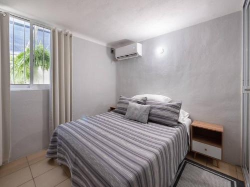 1 dormitorio con 1 cama con manta a rayas y ventana en Apartment in Puerto Vallarta, en Puerto Vallarta