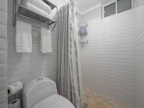 y baño blanco con aseo y ducha. en Apartment in Puerto Vallarta, en Puerto Vallarta