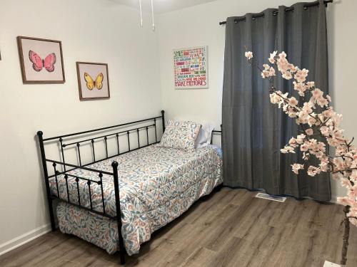 a bedroom with a bed and a window with flowers at Modern Home Near Uptown CLT, Airport and More in Charlotte