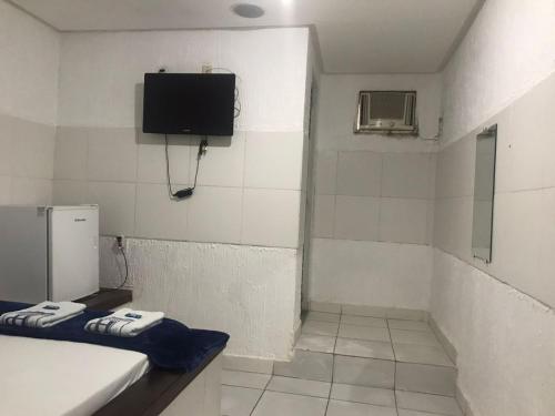 La salle de bains est pourvue d'une baignoire et d'une télévision murale. dans l'établissement HOTEL PRESIDENTE, à Belém