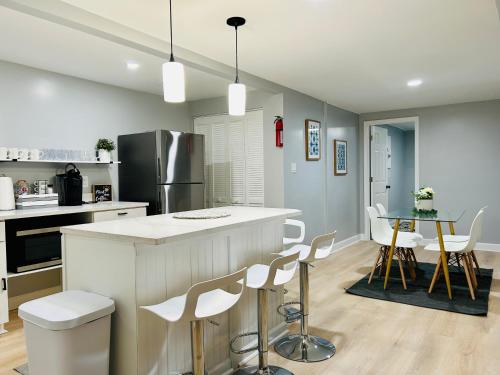 a kitchen with a white counter and chairs in it at Comfy Lower Lvl Apt with Jetted Tub Near Uptown and UNC in Charlotte