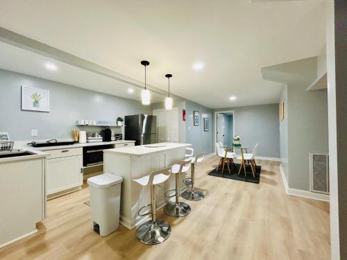 a large kitchen with a counter and chairs in it at Comfy Lower Lvl Apt with Jetted Tub Near Uptown and UNC in Charlotte