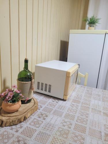 a microwave and a bottle of wine on a table at Pousada Justi Oliveira in Louro Müller