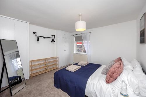 a bedroom with a bed with a blue blanket at Entire house in Paddock Wood, United Kingdom in Paddock Wood
