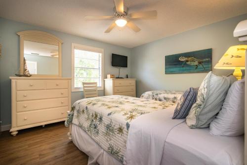 um quarto com 2 camas e uma ventoinha de tecto em Peace 'n Paradise em Holmes Beach