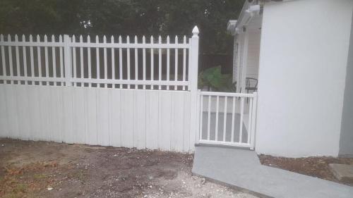 a white fence with a gate in a yard at BU2 · Beatiful unit near Adv Island/ BuschGardens in Tampa