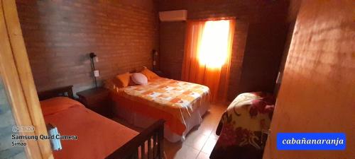 Habitación pequeña con 2 camas y ventana en LO DE MERY en Termas de Río Hondo