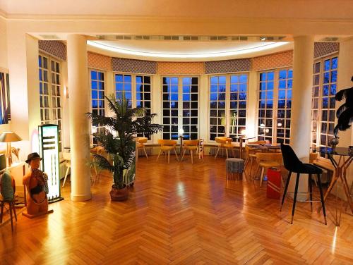 a large room with tables and chairs and windows at Quand la ville dort in Agen
