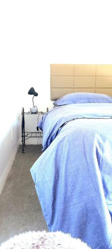 a bedroom with a bed with a blue blanket on it at Pousada IMcasa 430 in Bento Gonçalves